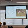 Spring 2026 capstone students stand by a projection screen that details the importance of the HPBH WSA