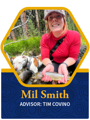 Mil Smith Profile pic of her holding a fish by a river and smiling