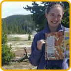 image of woman holding up a magazine and smiling in Yellowstone National Park